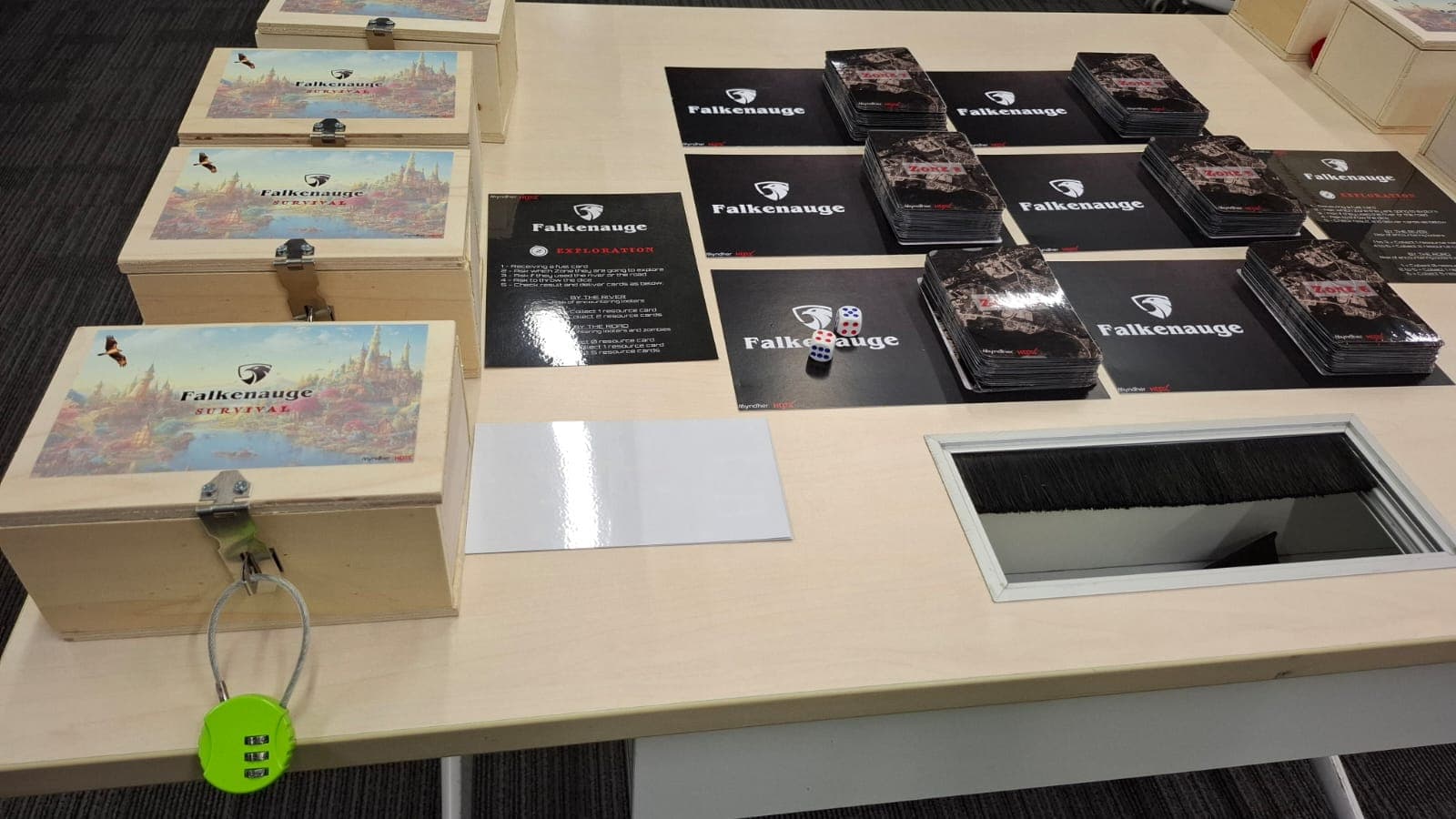 A room set up before a Falcon Eye session: village kits in padlocked wooden crates and Falkenauge boards laid out across a table.