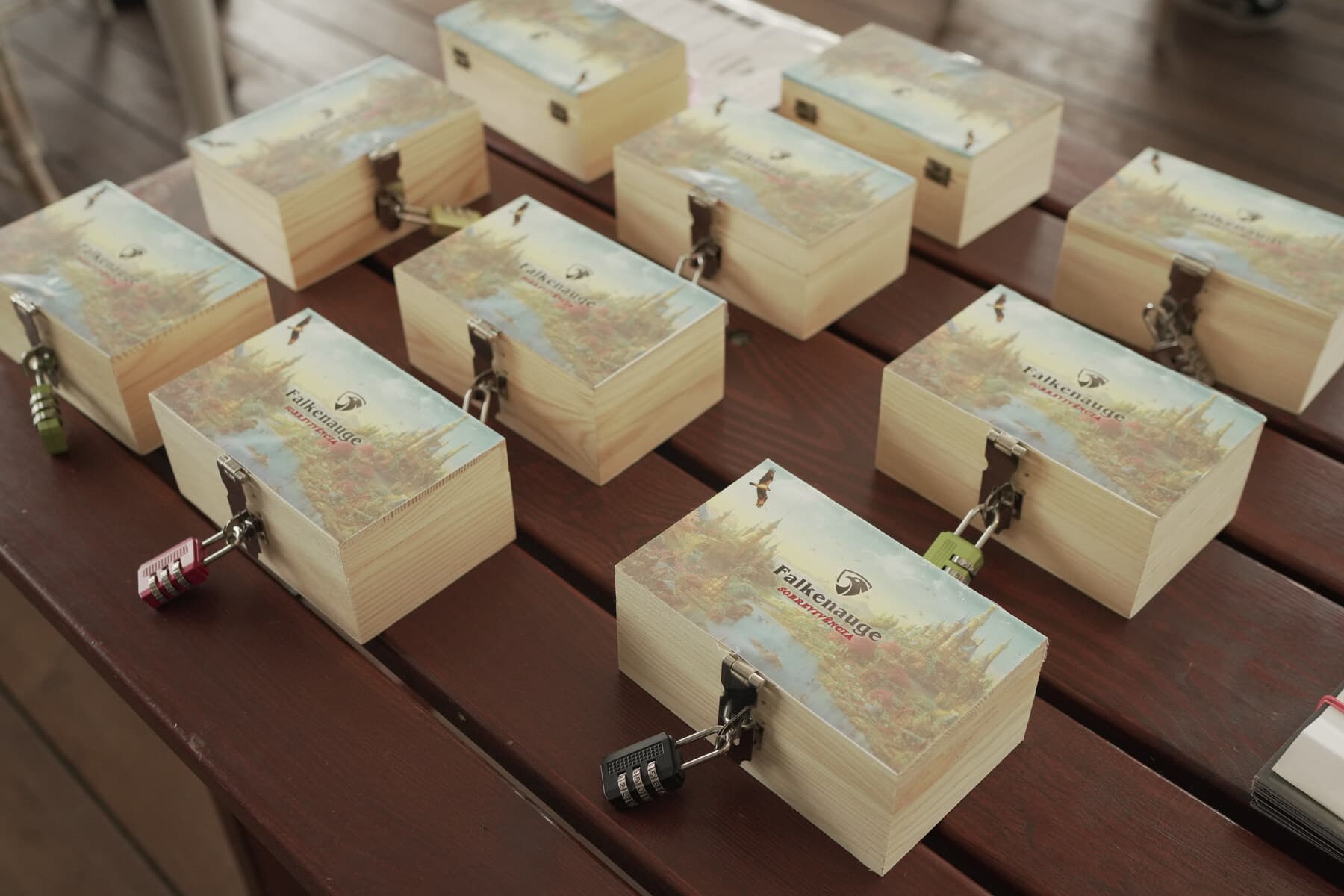 Nine Falcon Eye village crates laid out before a session, each printed with the territory artwork and sealed with its own combination padlock.